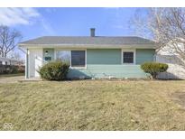 Charming single-story home with light green siding, complemented by a well-maintained lawn and minimal landscaping at 4876 Barlow Dr, Indianapolis, IN 46226
