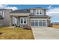 Charming two-story home features gray siding, stone accents, and a two-car garage at 6781 Seattle Slew Dr, Whitestown, IN 46075