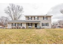 Two-story house with gray siding, brick accents, and a landscaped lawn at 8139 Hi Vu Dr, Indianapolis, IN 46227