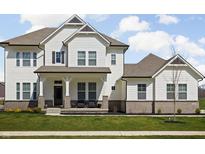 Beautiful two-story home with white siding, a covered front porch, and a well-manicured lawn at 16012 Forewood Ln, Fishers, IN 46037