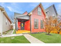 Charming red house with black trim, inviting covered porch, and well-manicured front lawn at 1705 Hoyt Ave, Indianapolis, IN 46203