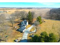 An aerial view shows the property's buildings and long driveway to the home surrounded by a field at 22351 Cyntheanne Rd, Noblesville, IN 46060