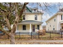 Two-story house with a front porch and a black metal fence at 317 N Arsenal Ave, Indianapolis, IN 46201