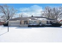 Charming brick home with attached garage and a snow-covered front yard in a residential neighborhood at 3535 Dogwood Dr, Anderson, IN 46011