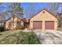 Charming brick home with an attached two-car garage and well-maintained landscaping at 8349 Tequista Cir, Indianapolis, IN 46236