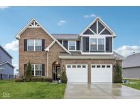 Charming two-story brick home with a two-car garage, manicured lawn, and beautiful architectural details at 1006 Cherry Tree Ln, Greenwood, IN 46143