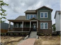 Charming two-story home featuring a welcoming front porch and a combination of brick and siding exterior at 19997 Old Dock Rd, Westfield, IN 46074
