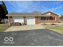 Brick house with a large driveway and an attached two car garage with a neatly maintained front yard at 2003 Alexandria Dr, Greenfield, IN 46140