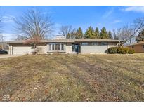 Charming single-story home featuring a stone facade, attached garage, and well-maintained front yard at 2016 Colt Rd, Indianapolis, IN 46227