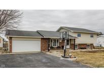 Two-story home features brick and siding exterior, attached garage, and a basketball hoop in the driveway at 362 1400 N, Summitville, IN 46070