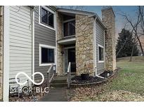 Charming townhouse features stone accents, gray siding, and well-maintained landscaping at 5746 Overcrest Dr, Indianapolis, IN 46237