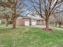 Charming home featuring a brick facade, multi-car garage, and well-manicured lawn at 6366 Amber Pass, Plainfield, IN 46168