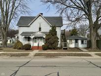 Two-story home with a wraparound porch and mature trees at 714 West Washington St, Shelbyville, IN 46176