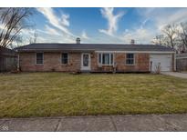 Brick ranch house with a spacious lawn, attached garage, and a front porch at 770 Berkley Dr, Fortville, IN 46040