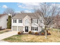 Charming two-story home with brick and vinyl siding, attached garage, and well-manicured landscaping at 10400 Hillsborough Dr, Fishers, IN 46037