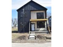 Modern two-story home featuring black siding, large windows, and a covered porch, in a construction phase at 1523 N Beville Ave, Indianapolis, IN 46201