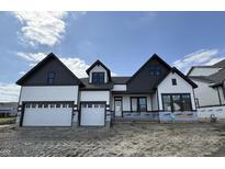 New two-story home boasts an attached three-car garage, modern architecture, and dark-trimmed windows at 19826 Chatham Shore Ln, Westfield, IN 46074