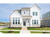 Two story home with mixed siding, stone accents, black front door, covered porch, and manicured front lawn at 19995 Meadow Neck Rd, Westfield, IN 46074