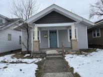 Charming home featuring light gray siding, brick-based pillars, and a covered porch at 2029 Laurel St, Indianapolis, IN 46203