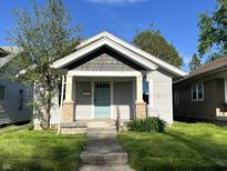 Charming single-story home with light gray siding and a welcoming light blue front door at 2029 Laurel St, Indianapolis, IN 46203