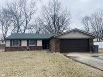 Charming single-story home with brick and siding exterior, a green roof, and an attached two-car garage at 3330 Corey Dr, Indianapolis, IN 46227