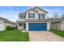 Charming two-story home with blue accents, attached two car garage and inviting curb appeal at 411 Red Tail Ln, Indianapolis, IN 46241