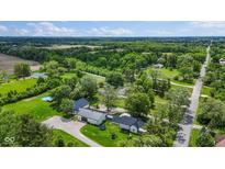 Lovely aerial shot of a charming farmhouse-style home surrounded by green pastures and trees at 4131 N County Road 500 E, Danville, IN 46122