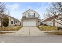 Exterior view of two-story home with vinyl siding, well-manicured lawn, and attached garage at 5655 Cheval Ln, Indianapolis, IN 46235