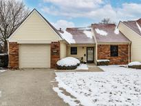 Charming single-story townhome featuring a private entrance, attached garage, and cozy, snow-covered front yard at 6416 Friendship Cir, Indianapolis, IN 46268