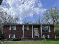 Charming brick home featuring large windows, white trim, and a cozy front porch at 6632 Sargent Rd, Indianapolis, IN 46256