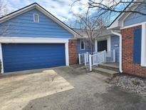 Charming exterior of blue home with a blue garage door, brick accents, and a welcoming front entrance at 8001 Tanager Ln, Indianapolis, IN 46256
