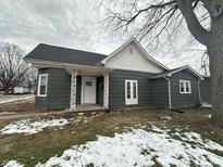 Charming home featuring green siding, a white-trimmed roof, and decorative front porch posts at 806 S 17Th St, Elwood, IN 46036