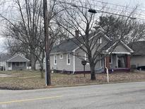 Traditional home exterior features gray siding, a brick foundation, and a welcoming front porch at 111 S Gladstone Ave, Columbus, IN 47201