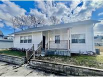 Charming home with a stucco exterior, inviting front porch, and well-maintained landscaping at 117 W 36Th St, Indianapolis, IN 46208