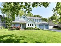 Charming two-story home with blue trim, attached garage, and lush green lawn at 11710 E 75Th St, Indianapolis, IN 46236