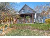 Charming two-story home with a covered porch and landscaped front yard with green hedges at 1209 E Vermont St, Indianapolis, IN 46202