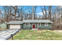 Charming one-story home with an attached garage, a red front door, and mature trees at 135 Boring Pl, Martinsville, IN 46151