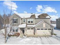 Beautiful two-story home featuring a three-car garage and neutral siding, surrounded by a snowy winter landscape at 15530 Whelchel Dr, Fishers, IN 46037