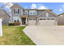 Charming gray two-story home features a three-car garage and well-maintained front yard at 15530 Whelchel Dr, Fishers, IN 46037