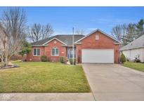 Beautiful red brick home featuring an attached two-car garage and a well-maintained front yard at 2209 Keystone Pl, Columbus, IN 47203