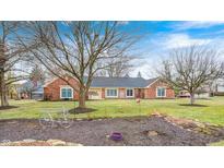 Charming brick home featuring a well-maintained lawn and inviting curb appeal with colorful landscaping at 295 Camden Dr, Zionsville, IN 46077