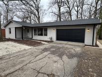 Charming home with updated painted white brick, black trim and a well-maintained front yard at 315 S Rangeline Rd, Anderson, IN 46012