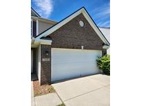 Attached two-car garage with brick facade and well-maintained concrete driveway at 3416 Firethorn Dr, Whitestown, IN 46075