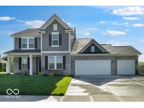 Charming two-story home with a brick and gray siding exterior and a spacious three car garage at 567 Hidden Hills Dr, Pittsboro, IN 46167