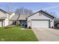 Charming home featuring an attached two-car garage and a well-manicured front yard at 8211 River Bay E Dr, Indianapolis, IN 46240
