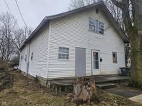 Two-story home featuring white siding, multi-pane windows, and a modest front porch at 1031 Nichol Ave, Anderson, IN 46016