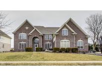 Stunning two-story brick home with a well-manicured lawn, arched entryway, and plenty of windows at 11478 Muirfield Trce, Fishers, IN 46037