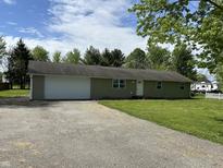 Ranch style home with attached garage, concrete drive, and well-kept lawn at 1435 E New Rd, Greenfield, IN 46140