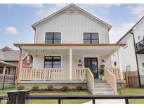Charming two-story home featuring a welcoming front porch with stylish railings and modern black-framed windows at 2021 Carrollton Ave, Indianapolis, IN 46202