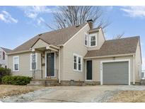 Charming tan house with a covered porch, attached garage, and well-maintained yard at 354 W 38Th St, Anderson, IN 46013